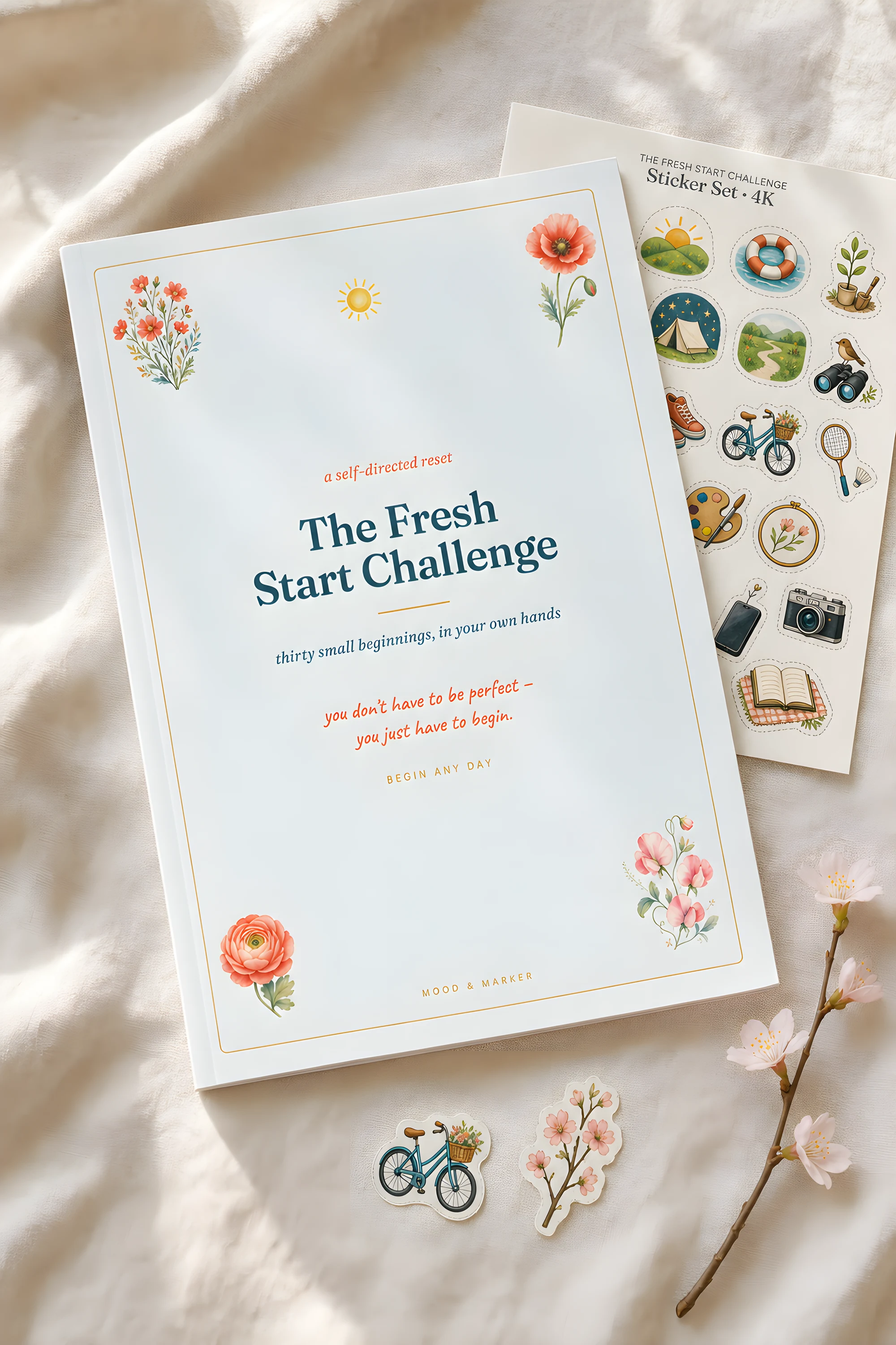 The Fresh Start Challenge printed and laid on cream linen — its sticker sheet peeking behind, two loose stickers and a blossom sprig